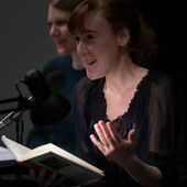 Close-up of Nora Bossong reading aloud, Hannah Markus sits behind her.