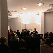 Gut gefüllter Publikumsraum mit Matthias Schwartz und Olga Grjasnowa im Hintergrund.