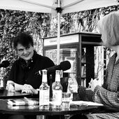 Iris Hanika und Ulrike Vedder sitzen auf einer kleinen Bühne und unterhalten sich.