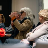 Eine Person im Publikum spricht gestikulierend.