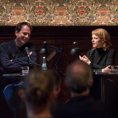 Bov Bjerg und Christine Kutschbach sitzen am Lesetisch, Christine Kutschbach spricht, Bov Bjerg lacht