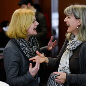Two participants of the event talk to each other and laugh