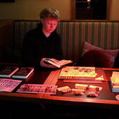 Nicola Chodan sits at a display table with information brochures and books.