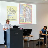 Christina Wessely stands at the lectern and speaks to the audience.