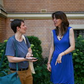 Anna Hetzer und Janika Gelinek stehen im Garten vor dem Literaturhaus und unterhalten sich. Hetzer hält ein Headset in der Hand.
