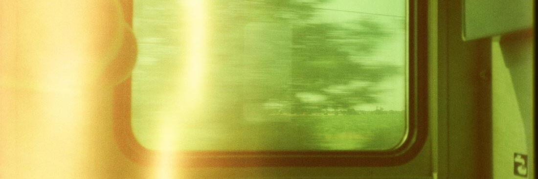 Blick aus dem Fenster eines fahrenden Zugs.