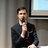 Lukas Laier spricht ins Mikrofon und schaut ins Publikum.