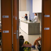 Looking through the door of the lecture hall. At the lectern, Maggie Nelson is reading, Eva Axer is standing next to her.