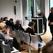 Moritz Baßler steht am Rednerpult und geht auf Fragen aus dem Publikum ein