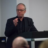 Dirk Baecker trägt hinter dem Vortragspult vor