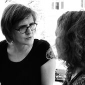 Schwarz-Weiß-Fotografie von Xxx und Mona Körte, die beiden sind in ein Gespräch vertieft.