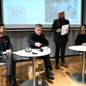 Lukas Laier, Christoph Hesse und Anja Kunzmann sitzen an zwei Bistrotischen, zwischen ihnen steht Claude Haas und spricht zum Publikum. Hinter ihm ist auf einer Leinwand ein Bild Hermann Borchardts zu sehen.