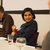 Heba Amin an einem Konferenztisch, sie blickt einen anderen Teilnehmer der Konferenz an.