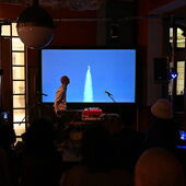 During his performance, musician Adi Gelbart looks at the screen mounted behind him, which shows the launch of a rocket.