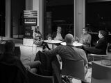 Schwarz-weiß Bild: Podiumsdiskussion mit vier Gästen und Publikum