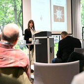 Susan Morrow steht am Rednerpult und spricht zum Publikum.