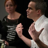 Stephan Thome speaks into a microphone and gestures while Christina Pareigis listens to him