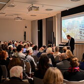 Michael Mönninger steht am Rednerpult und spricht zum Publikum.