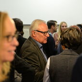 Aage Hansen-Löve steht unter Menschen, Susi K. Frank unscharf im Vordergrund