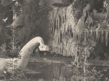 Historische Schwarzweiß-Inszenierung einer urzeitlichen Landschaft mit Dinosauriermodell zwischen künstlichen Felsen, Tannen und kleinem Teich in einem Innenraum.