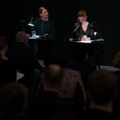 Wide shot of Hannah Markus and Nora Bossong in front of audience