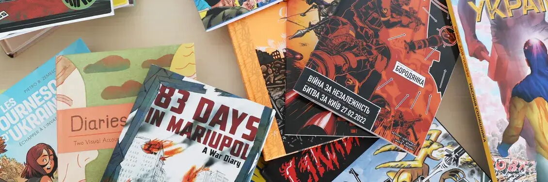 Photo of various comic books in French, English, and Ukrainian that address the war in Ukraine.