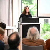 Elisa Ronzheimer steht am Rednerpult und spricht zum Publikum.