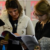 Two participants read in the event brochure