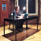 Lara Körte sitzt am Lesetisch und liest aus einem Buch