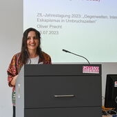 Judith Lippelt stands at the lectern and speaks to the audience.