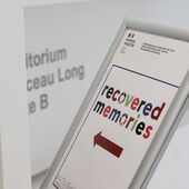 Aufsteller mit einem Plakat zur Konferenz »Recovered Memories« und einem roten Pfeil Richtung Auditorium.