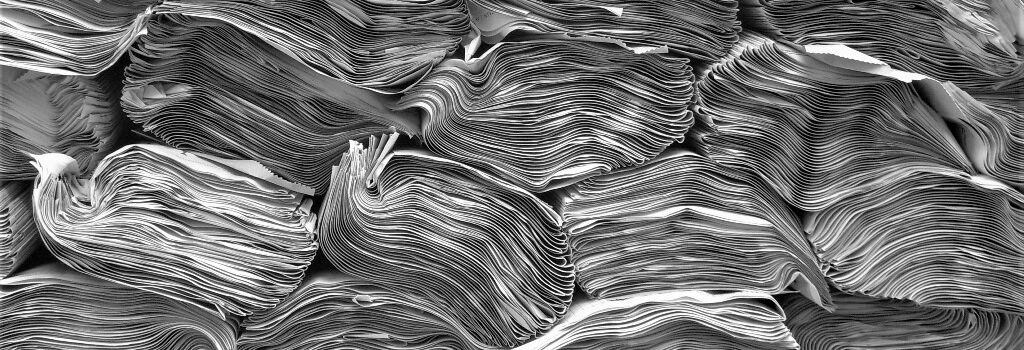 Black and white photo of several very thick stacks of magazines close together from the side view. Together they form a wavy pattern.