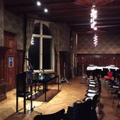 Empty, old-fashioned style reading room with chairs, a table in front and microphones