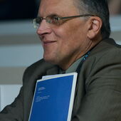Manfred Krifka holds a brochure and smiles