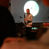 Musician Adi Gelbart plays the saxophone in front of an audience.
