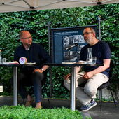 Stefan Willer und Andreas Bernard sitzen auf der Bühne im Garten des Literaturhauses Berlin.