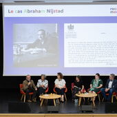 Sechs Personen sitzen auf dem Podium und diskutieren, auf der Leinwand hinter ihnen sind ein Bild Abraham Nijstads und der Scan eines Archivdokuments zu sehen.