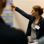 Hannah Markus trägt vor und deutet dabei auf ein Plakat