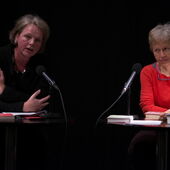 Ulrike Vedder speaks into a microphone, next to her Ulrike Draesner sits behind a second microphone and listens