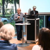 Vier Personen stehen vor der Leinwand und diskutieren.