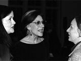 Black and white photograph of x, x and x. The three women are talking animatedly.