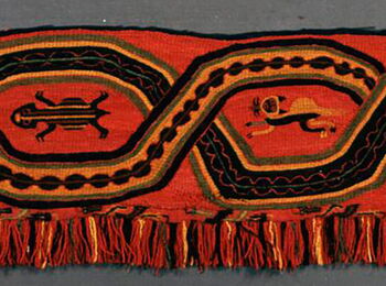 Red textile band with black and orange geometric ornaments and stylized animal figures, finished with fringes along the lower edge.