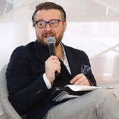 Zaal Andronikashvili moderates a panel discussion, he speaks into a microphone and looks to the right.