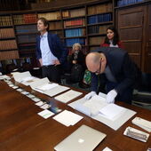 Workshopteilnehmer begutachten Schriftstücke und Fotografien.