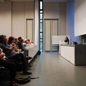 Maggie Nelson stands at the lectern in a packed lecture hall and speaks to the audience.