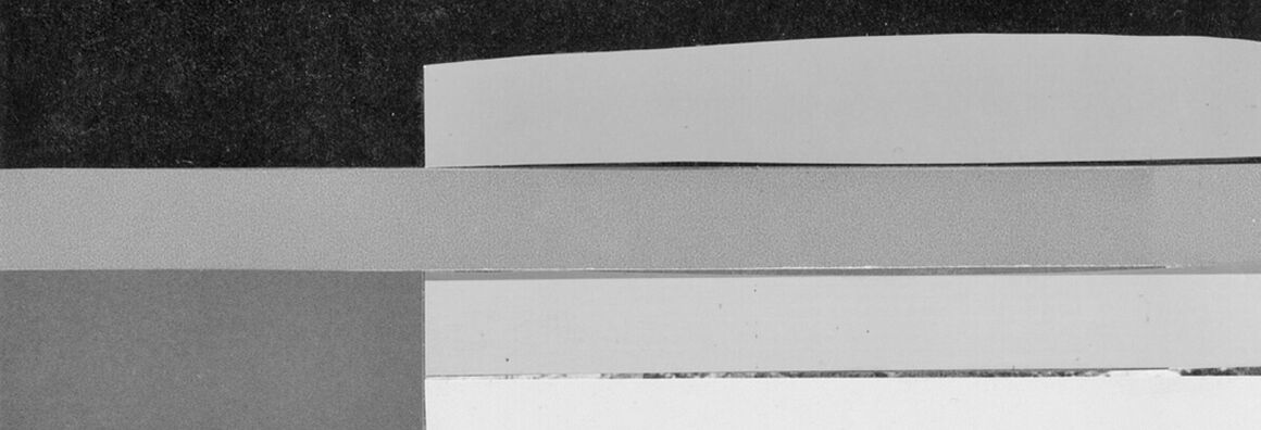 Negative image of a bridge arch made of stone with water flowing under it.