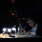 Tabea Hertzog und Cord Riechelmann sitzen an einem von kleinen Laternen beleuchteten Tisch im Freien. Cord Riechelmann spricht in ein Mikro.