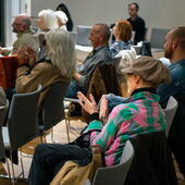 Personen im Publikum klatschen.