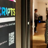 Eingang zum Eberhard-Lämmert-Saal. Links ist ein Plakat des Exzellensclusters "SCRIPTS" zu sehen, rechts unscharfe Gestalten.