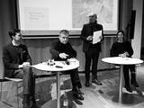 Lukas Laier, Christoph Hesse und Anja Kunzmann sitzen an zwei Bistrotischen, zwischen ihnen steht Claude Haas und spricht zum Publikum. Hinter ihm ist auf einer Leinwand ein Bild Hermann Borchardts zu sehen.